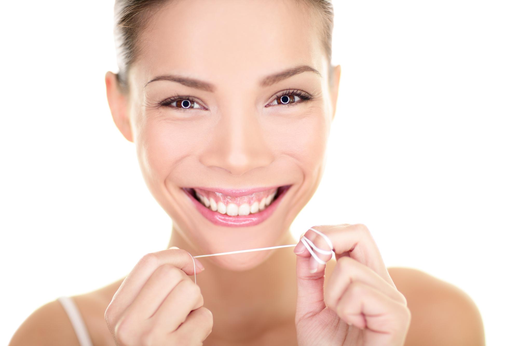 Dental floss - woman flossing teeth smiling
